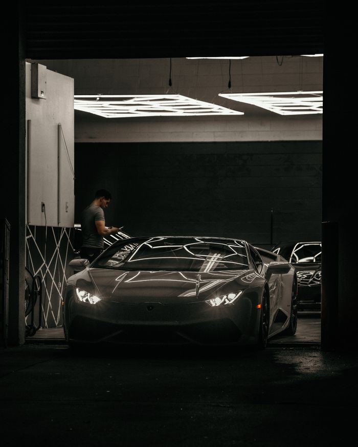 Sleek Lamborghini Aventador parked in a sophisticated modern garage, showcasing luxury design.